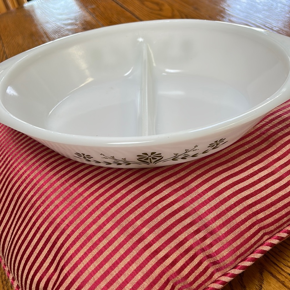 Vintage Glasbake white divided casserole dish with green daisy print.